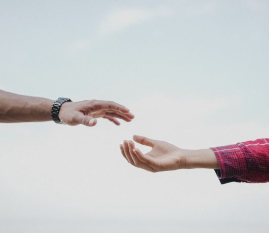 Two hands reaching towards each other, symbolizing connection and support.