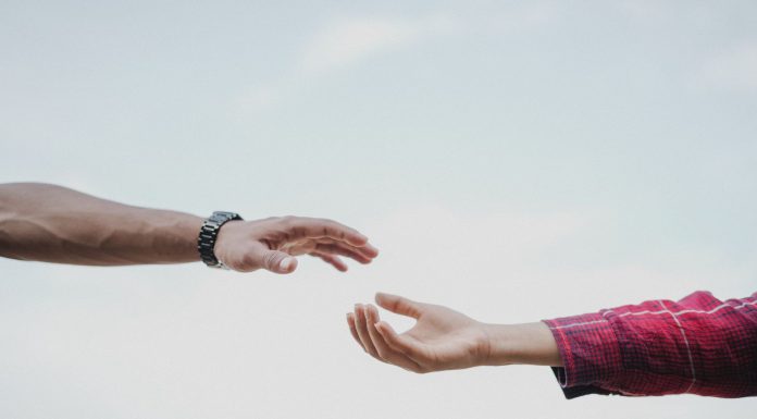Two hands reaching towards each other, symbolizing connection and support.