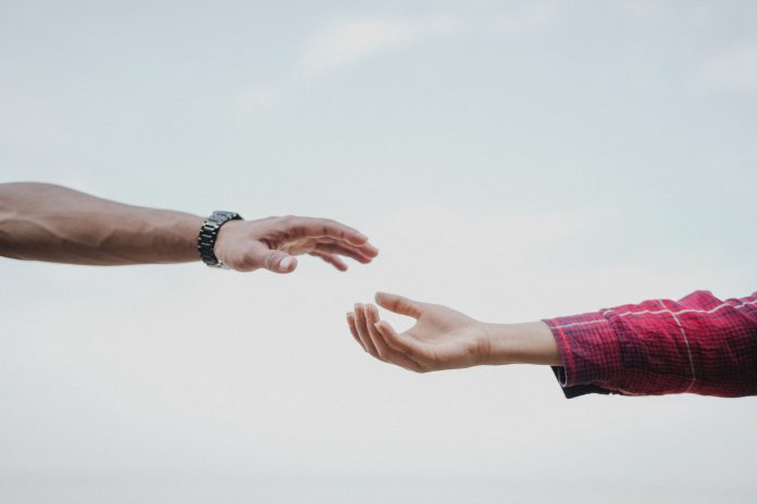 Two hands reaching towards each other, symbolizing connection and support.