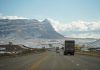 A winter road trip through mountainous terrain with vehicles on a scenic highway.