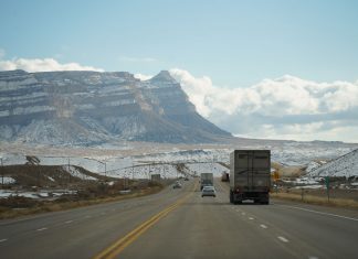A winter road trip through mountainous terrain with vehicles on a scenic highway.