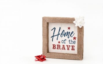 Patriotic framed sign with 'Home of the Brave' text and festive bows, perfect for home decor.