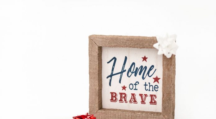 Patriotic framed sign with 'Home of the Brave' text and festive bows, perfect for home decor.