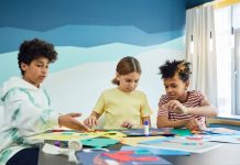 Programas Extraescolares en Bayonne 2026: Guía Completa para Padres Children focusing on an art project with colored papers in a playful art class setting.