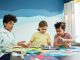 Programas Extraescolares en Bayonne 2026: Guía Completa para Padres Children focusing on an art project with colored papers in a playful art class setting.