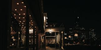 Qué Hacer de Noche en Jersey City: Guía Completa 2026 para Disfrutar la Vida Nocturna A stylish rooftop bar at night with a city skyline view and ambient lighting.