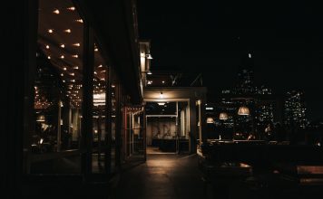 Qué Hacer de Noche en Jersey City: Guía Completa 2026 para Disfrutar la Vida Nocturna A stylish rooftop bar at night with a city skyline view and ambient lighting.