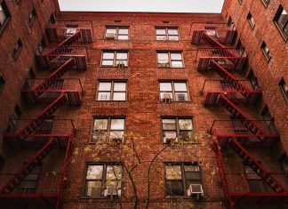 View of iconic red brick apartments with fire escapes in New York.