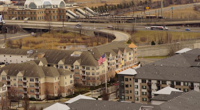Aerial view of urban residential apartments featuring an American flag, depicting city life.