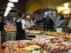 Shoppers wearing masks buy pizza slices from a bakery in Bergamo, Italy.
