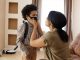 A mother helps her young son wear a face mask, creating a touching family moment indoors.