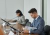 Business professionals in a conference setting, focusing on documents and reports.
