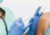 Close-up of a nurse in gloves giving a vaccination to a patient.