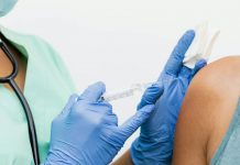 Close-up of a nurse in gloves giving a vaccination to a patient.