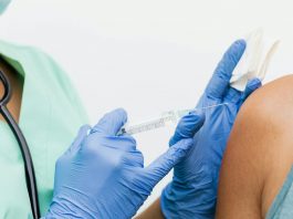 Close-up of a nurse in gloves giving a vaccination to a patient.