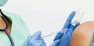 Close-up of a nurse in gloves giving a vaccination to a patient.