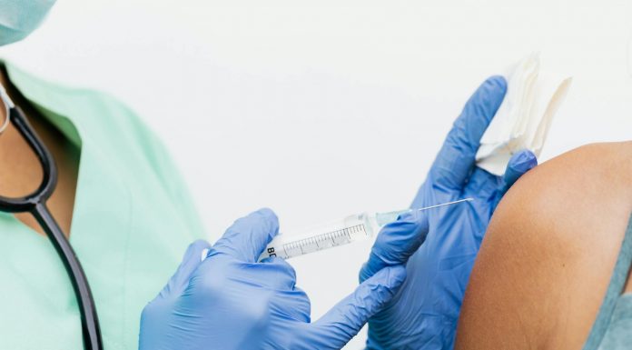Close-up of a nurse in gloves giving a vaccination to a patient.