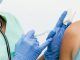 Close-up of a nurse in gloves giving a vaccination to a patient.