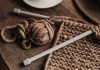 A close-up shot of cozy brown yarn and needles on a wooden table, showcasing knitting in progress.