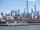USS Intrepid museum ship with NYC skyscrapers in the background.