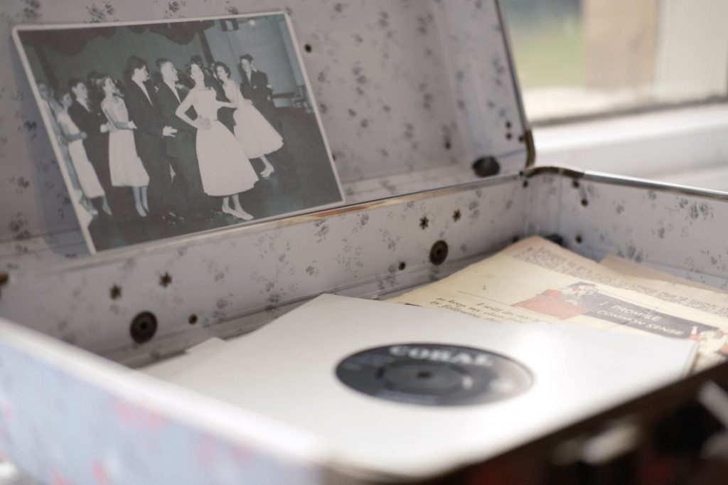 Open vintage floral suitcase with a classic photo and vinyl record inside.