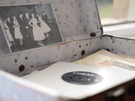 Open vintage floral suitcase with a classic photo and vinyl record inside.