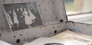 Open vintage floral suitcase with a classic photo and vinyl record inside.