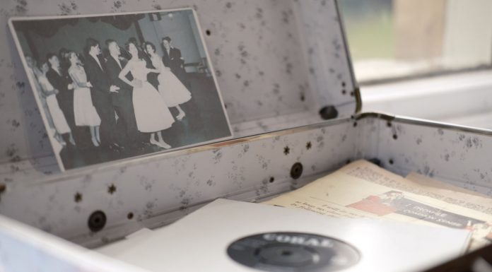 Open vintage floral suitcase with a classic photo and vinyl record inside.