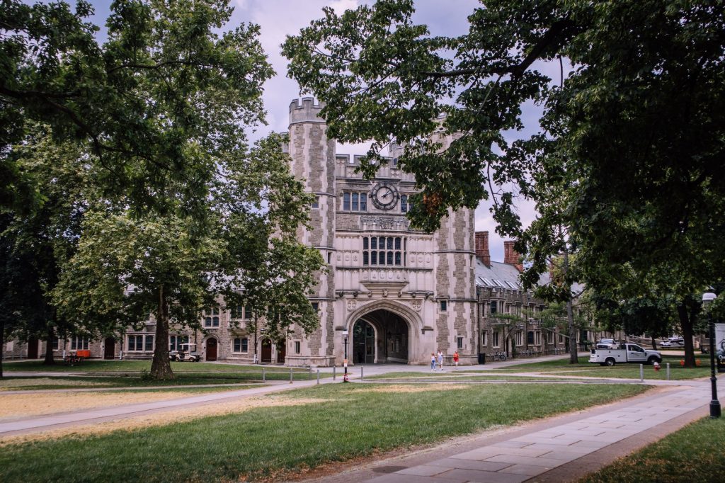 Explore the iconic gothic architecture of Princeton University, surrounded by lush greenery.