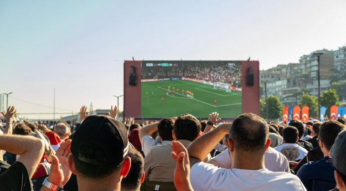 Crowd watching a soccer game on a large screen outdoors in Istanbul, Türkiye.