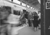 World Cup Match on a Tuesday Could Wreck Your Commute: Here’s What to Know A black and white scene of commuters at a Lisbon train station, showcasing urban movement.