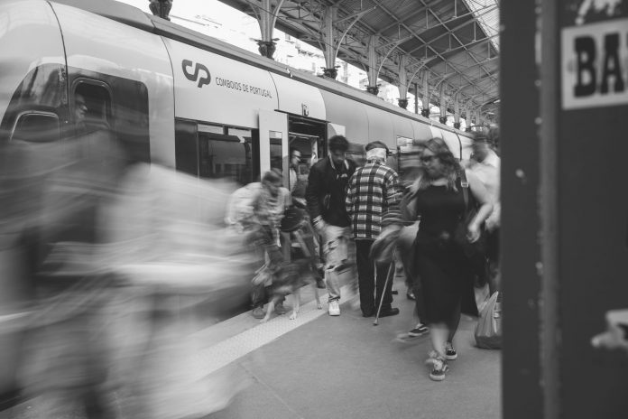 world-cup-match-on-a-tuesday-could-wreck-your-comm A black and white scene of commuters at a Lisbon train station, showcasing urban movement.