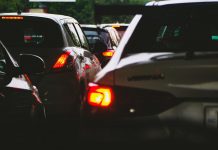 A close-up view of a traffic jam showcasing rear car lights glowing at dusk.