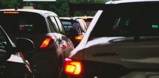 A close-up view of a traffic jam showcasing rear car lights glowing at dusk.