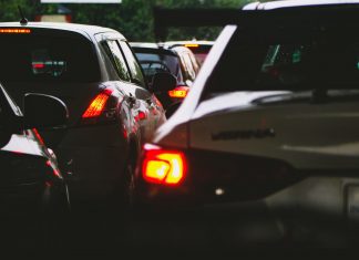 A close-up view of a traffic jam showcasing rear car lights glowing at dusk.