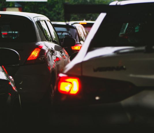A close-up view of a traffic jam showcasing rear car lights glowing at dusk.