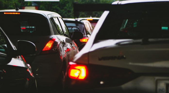 A close-up view of a traffic jam showcasing rear car lights glowing at dusk.