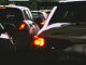 A close-up view of a traffic jam showcasing rear car lights glowing at dusk.