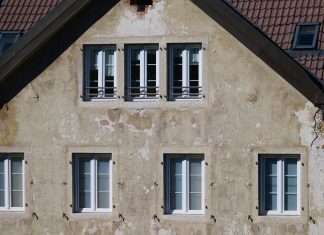 Close-up of an aged European house facade with multiple windows and rustic texture.