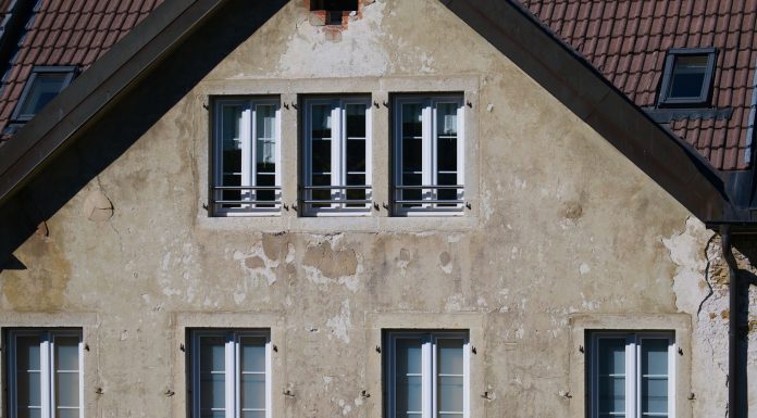 Close-up of an aged European house facade with multiple windows and rustic texture.
