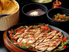 Tasty Mexican grilled chicken fajitas with colorful vegetables, tortillas, and sides, perfect for a savory meal.