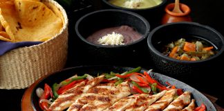 Tasty Mexican grilled chicken fajitas with colorful vegetables, tortillas, and sides, perfect for a savory meal.