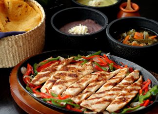 Tasty Mexican grilled chicken fajitas with colorful vegetables, tortillas, and sides, perfect for a savory meal.