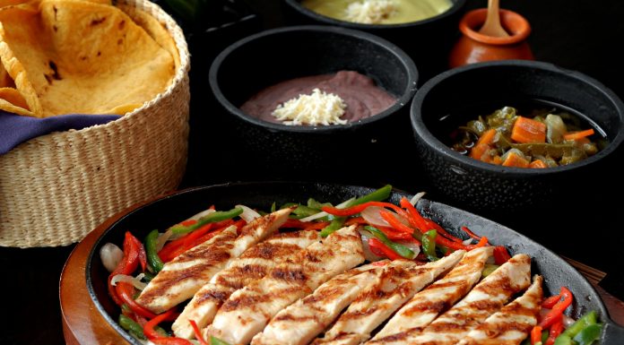 Tasty Mexican grilled chicken fajitas with colorful vegetables, tortillas, and sides, perfect for a savory meal.