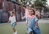 Three children enjoying a playful competition at an outdoor playground, showcasing motion and joy.