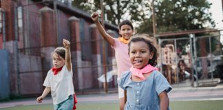 Actividades para Niños en Newark, NJ: Guía Completa 2026 Three children enjoying a playful competition at an outdoor playground, showcasing motion and joy.