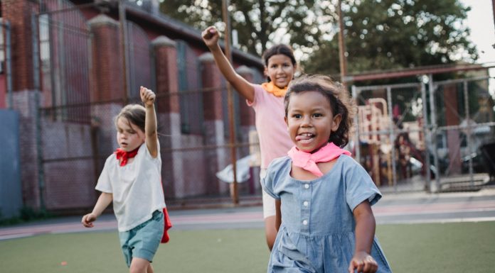 Three children enjoying a playful competition at an outdoor playground, showcasing motion and joy.