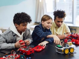 Diverse kids collaborating on robotics project, promoting STEM learning in a creative environment.