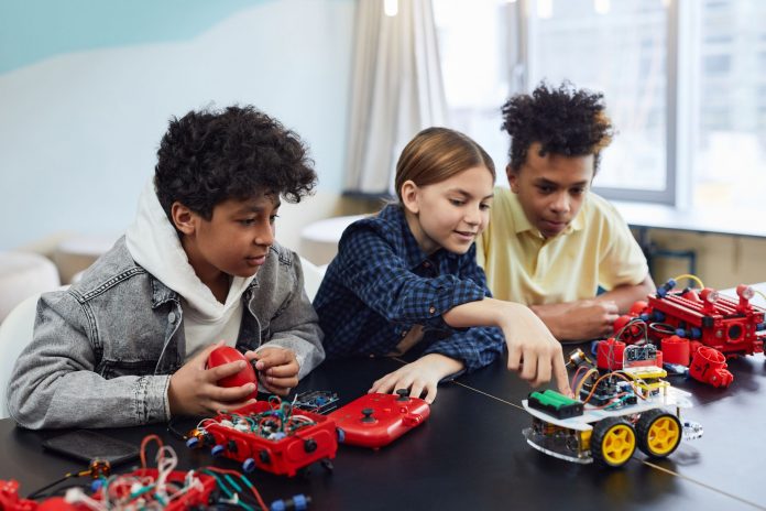 Diverse kids collaborating on robotics project, promoting STEM learning in a creative environment.
