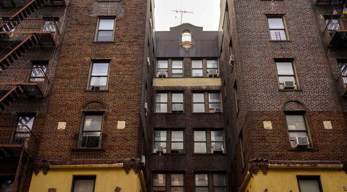 Los Mejores Apartamentos Baratos en Bayonne Ahora Mismo: Guía 2026 para Ahorrar Low-angle view of urban brick apartment buildings with fire escapes, embodying classic city architecture.